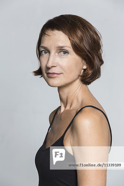 Side view portrait of confident woman against gray background