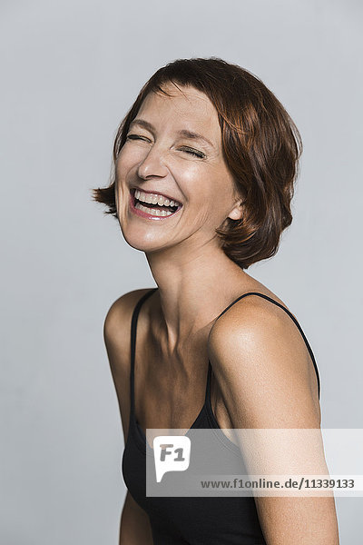 Cheerful mature woman against gray background