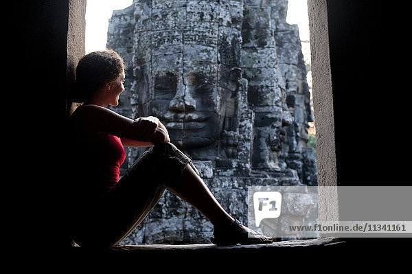 Ein Tourist schaut aus einem der Eingänge des Bayon-Tempels in Angkor  UNESCO-Weltkulturerbe  Siem Reap  Kambodscha  Indochina  Südostasien  Asien