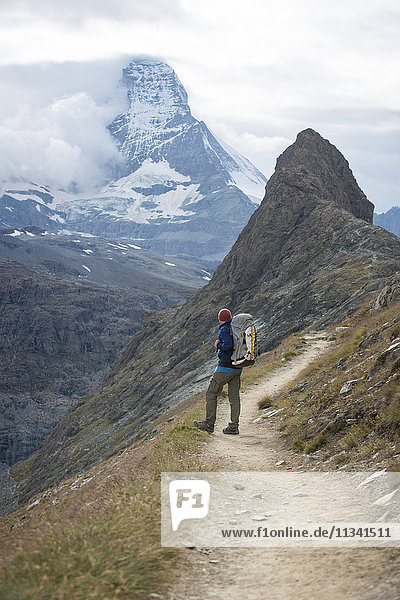 Hiking a trail in the Swiss Alps near Zermatt with a view of The Matterhorn in the distance  Zermatt  Valais  Switzerland  Europe