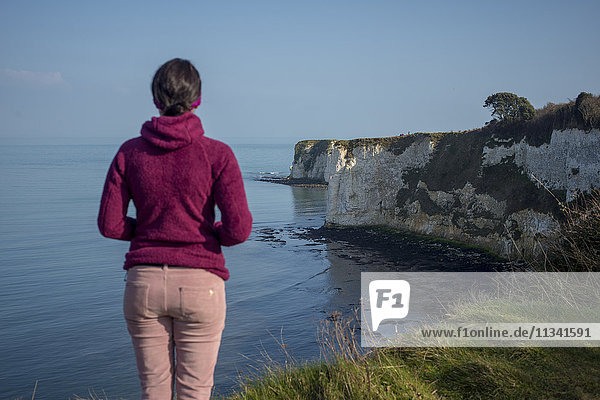 Eine Frau blickt auf die Old Harry Rocks an der Studland Bay  Jurassic Coast  UNESCO-Weltkulturerbe  Dorset  England  Vereinigtes Königreich  Europa