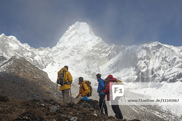A team of four climbers make their way to Ama Dablam Base Camp  the 6856m peak seen in the distance  Khumbu Region  Himalayas  Nepal  Asia