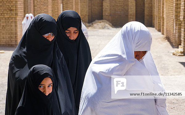Unterschiedliche Generationen  unterschiedliche Aussichten  Großmutter im selteneren weißen Tschador und Frauen und Enkelin im schwarzen Tschador  Varzaneh  Iran  Naher Osten