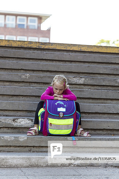 Mädchen sitzt mit Schulranzen auf der Treppe,  Kiel,  Schleswig-Holstein,  Deutschland,  Europa