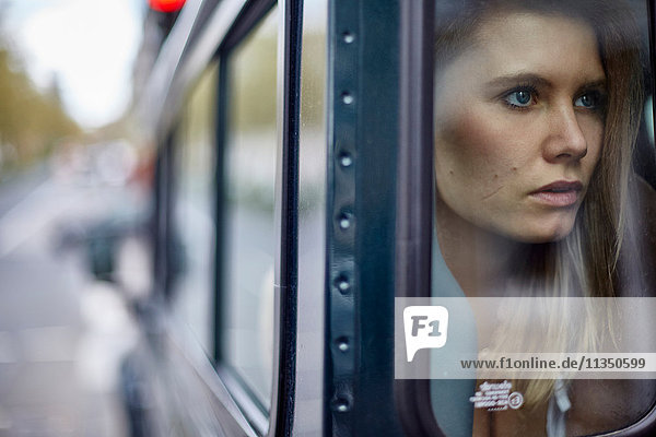Young woman behind car window looking out