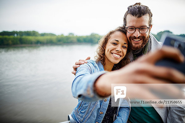 Young couple taking a selfie at the riverside
