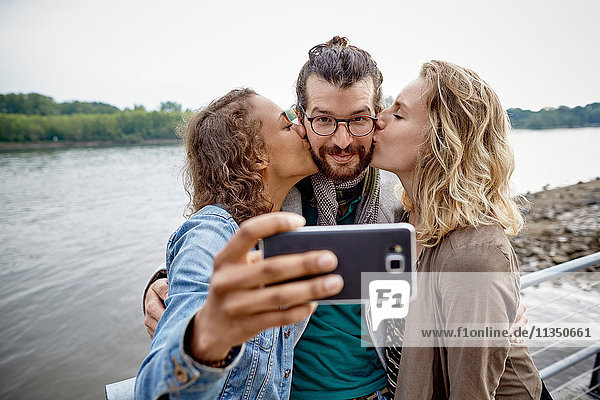 Freunde machen ein Selfie am Flussufer
