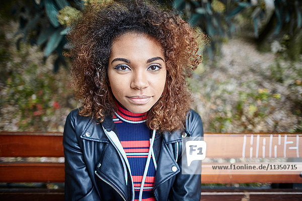 Portrait of young woman on park bench
