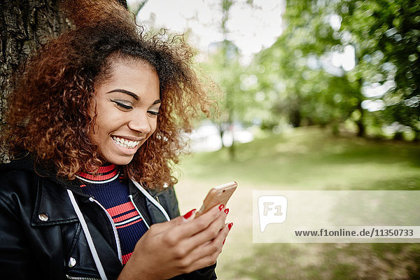Happy young woman looking on cell phone