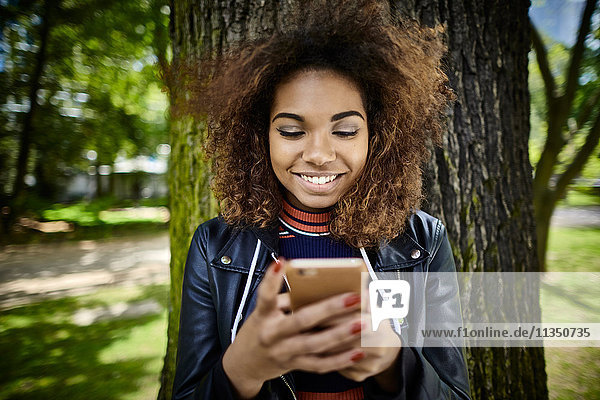 Happy young woman looking on cell phone