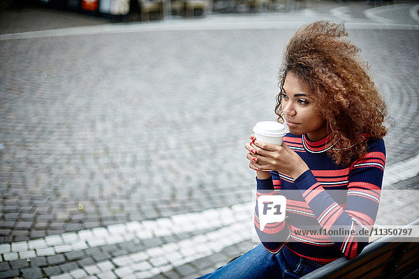 Young woman in the city with takeaway coffee