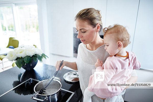 Mother with baby girl cooking