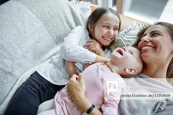 Mother with daughter and baby girl relaxing at home