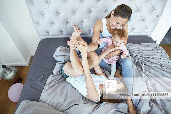 Mother with daughter and baby girl in bed