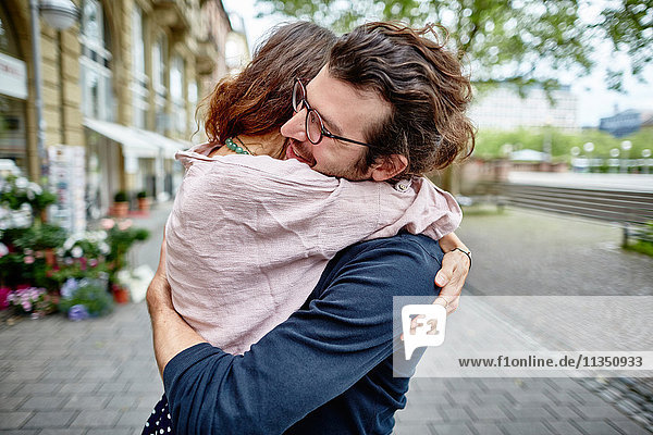 Glückliches junges Paar umarmt sich in der Stadt