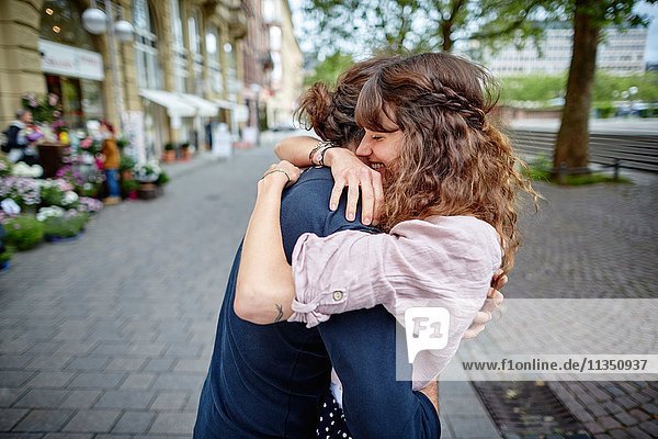 Glückliches junges Paar umarmt sich in der Stadt