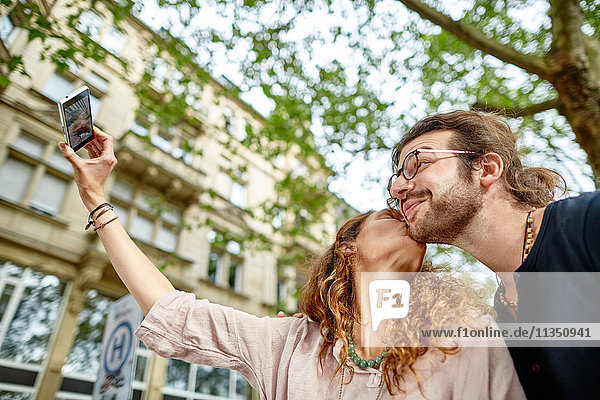 Glückliches junges Paar macht ein Selfie im Freien