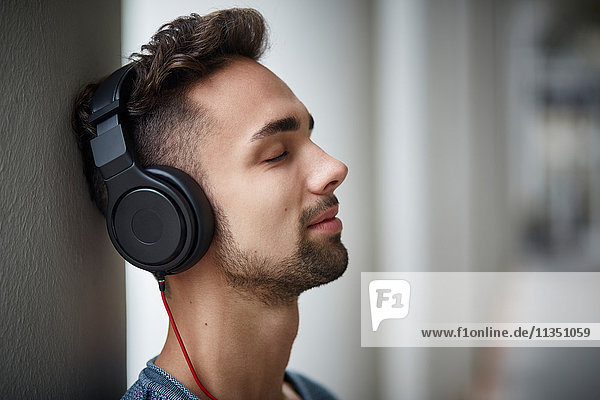 Young man wearing headphones outdoors