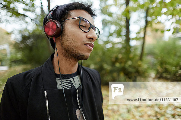 Young man wearing headphones in park