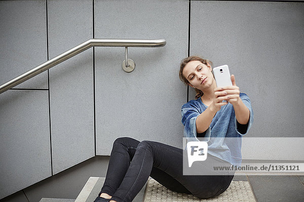 Young woman taking a selfie on stairs