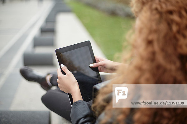 Teenagerin mit Tablet-PC im Freien