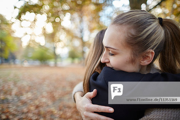 Two women hugging in park