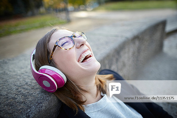 Fröhliche Frau mit Kopfhörern im Freien