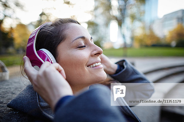Smiling woman wearing headphones outdoors