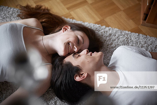 Junges Paar liegt auf einem Teppich auf dem Fußboden