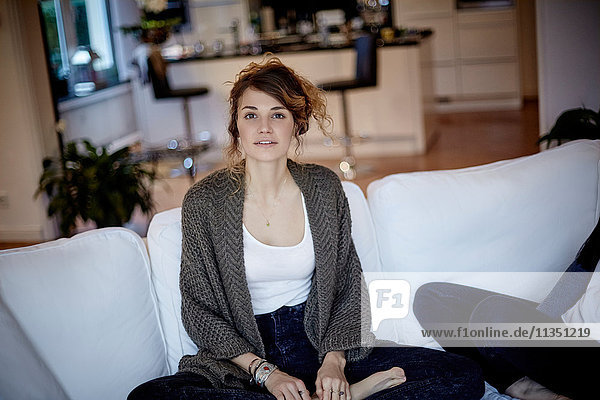 Portrait of young woman sitting on couch