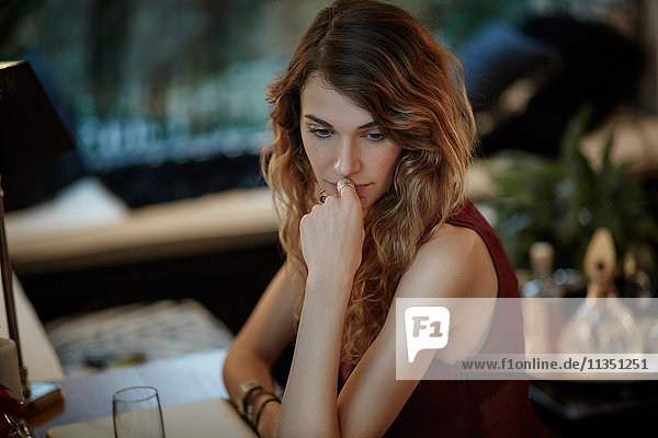 Serious young woman sitting at table