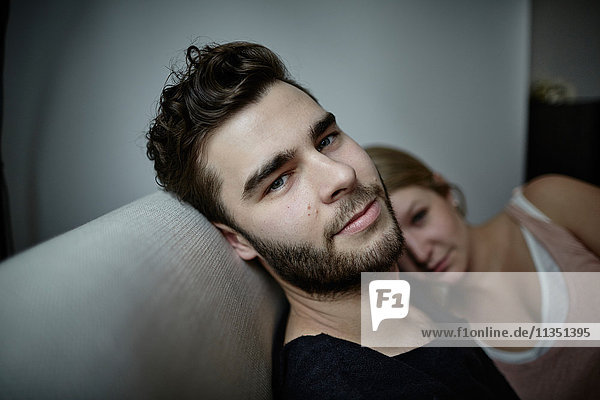 Portrait of young man with girlfriend on couch