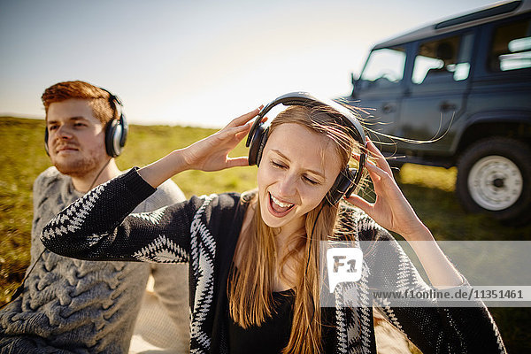Junges Paar hört Musik mit Kopfhörern