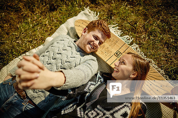 Smiling young couple lying on meadow