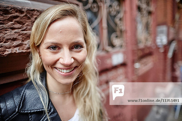 Portrait einer lächelnden blonden Frau im Freien
