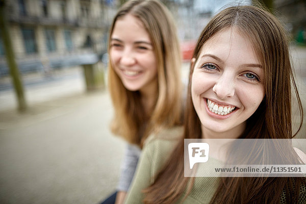 Portrait of happy young woman with female friend outdoors