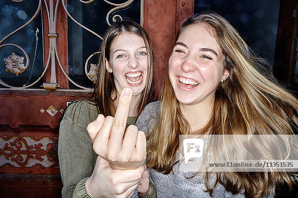 Zwei lachende junge Frauen albern herum