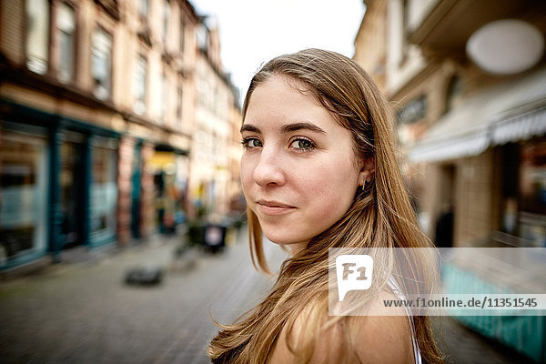 Portrait einer lächelnden jungen Frau in der Stadt
