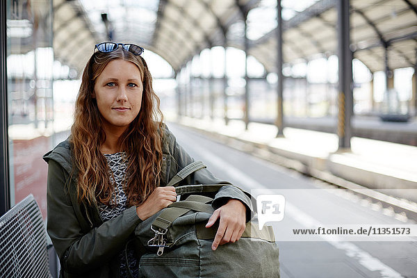 Portrait einer jungen Frau auf dem Bahnsteig