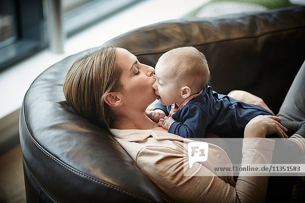 Mother and baby lying on couch