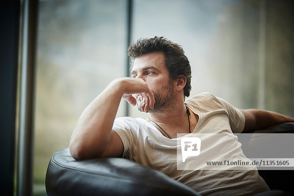 Pensive man sitting on couch