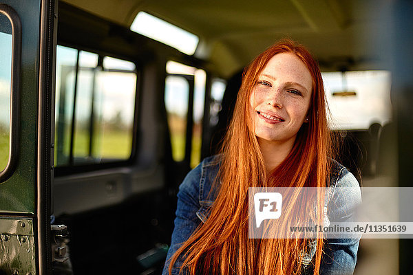 Portrait einer lächelnden jungen Frau im Auto