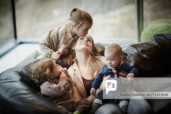 Mother with three children in living room