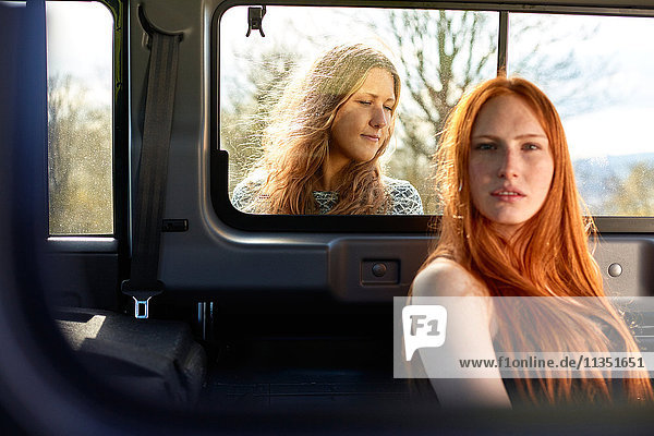 Junge Frau im Auto mit Freundin hinter dem Fenster