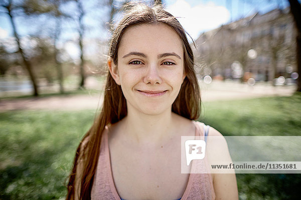 Portrait einer lächelnden Teenagerin in einem Park
