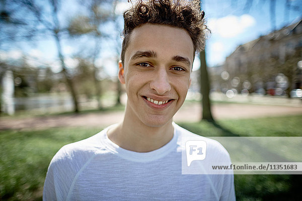Portrait of smiling teenage boy in park