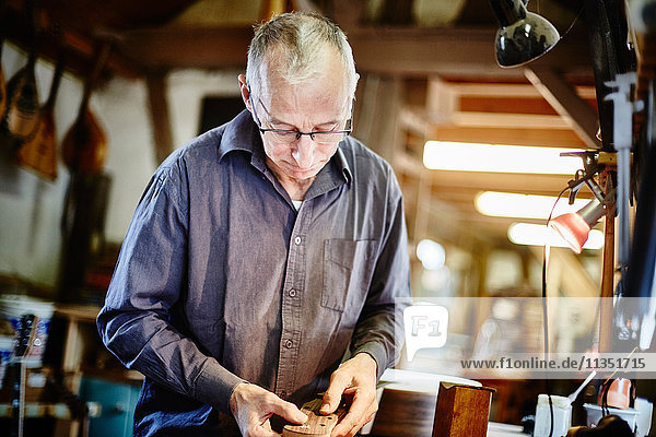 Guitar maker in his workshop at work