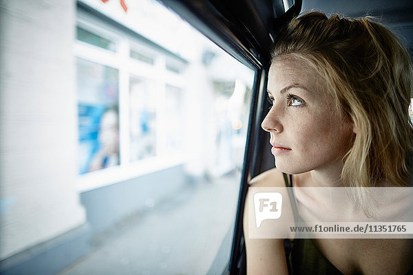 Young woman inside car looking out
