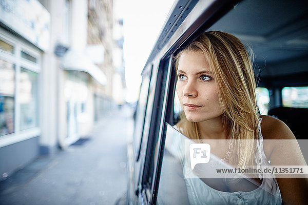 Junge Frau in einem Auto schaut hinaus
