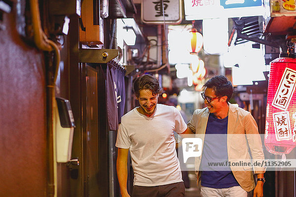 Kaukasischer Mann genießt das Nachtleben in Tokio mit japanischem Freund  Japan